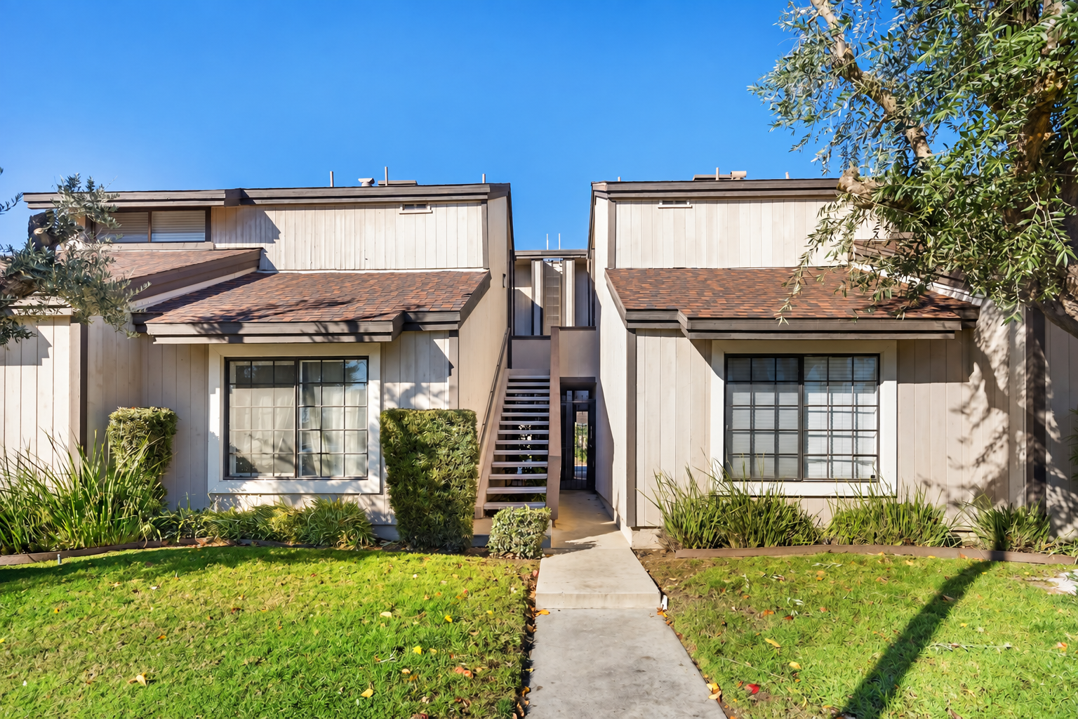 A well-kept Northern California apartment building surrounded by mature trees